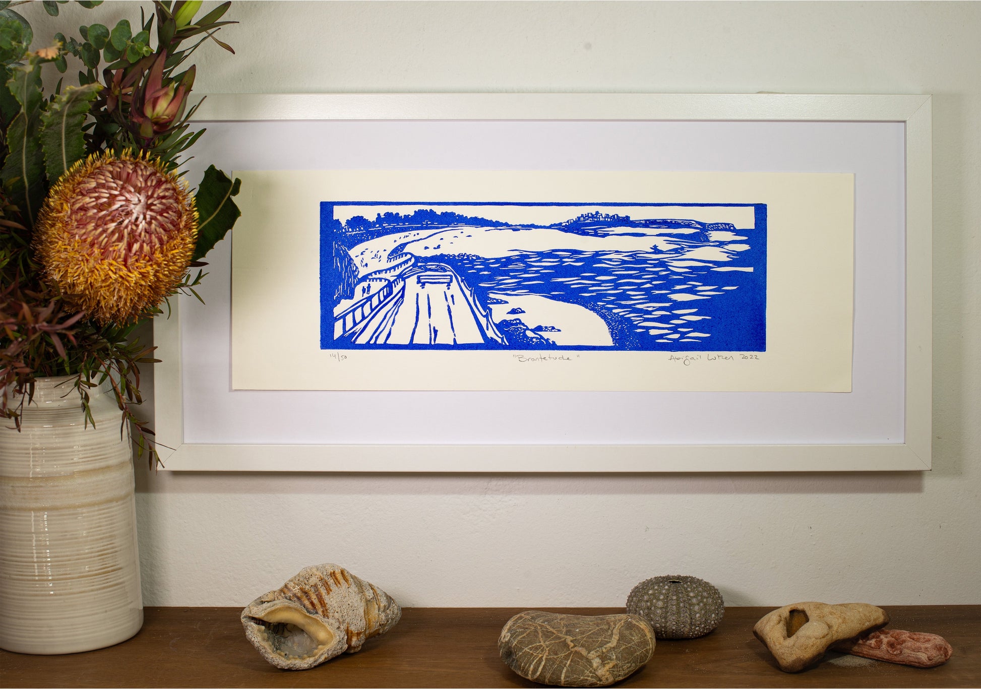 Brontetud linocut print, framed on a wall above a shelf