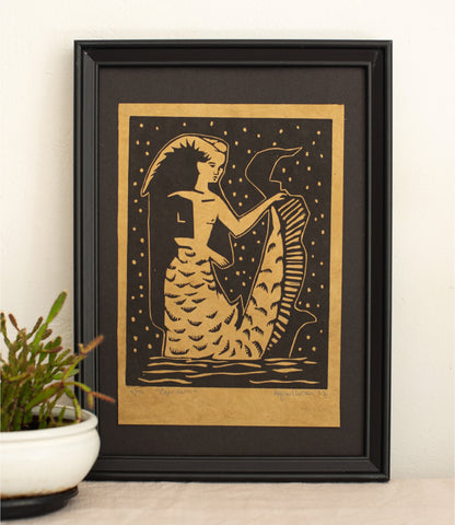 The Capricorn woodcut in a black frame, printed in gold and black