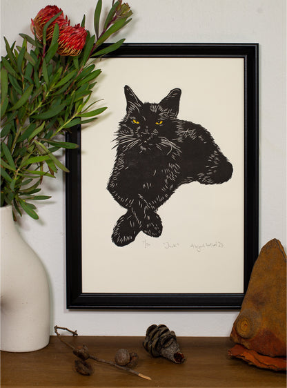 The Jack linocut in a white frame, beside a vase of native foliage