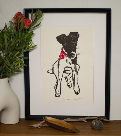 The Jilly Bean linocut in a white frame, beside a vase of native foliage