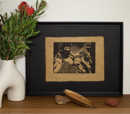The Mother Revolution linocut in a black frame, beside a vase of native flowers